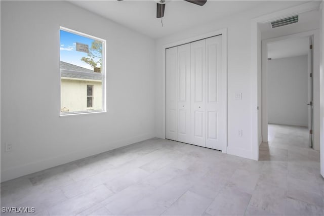 unfurnished bedroom featuring ceiling fan and a closet