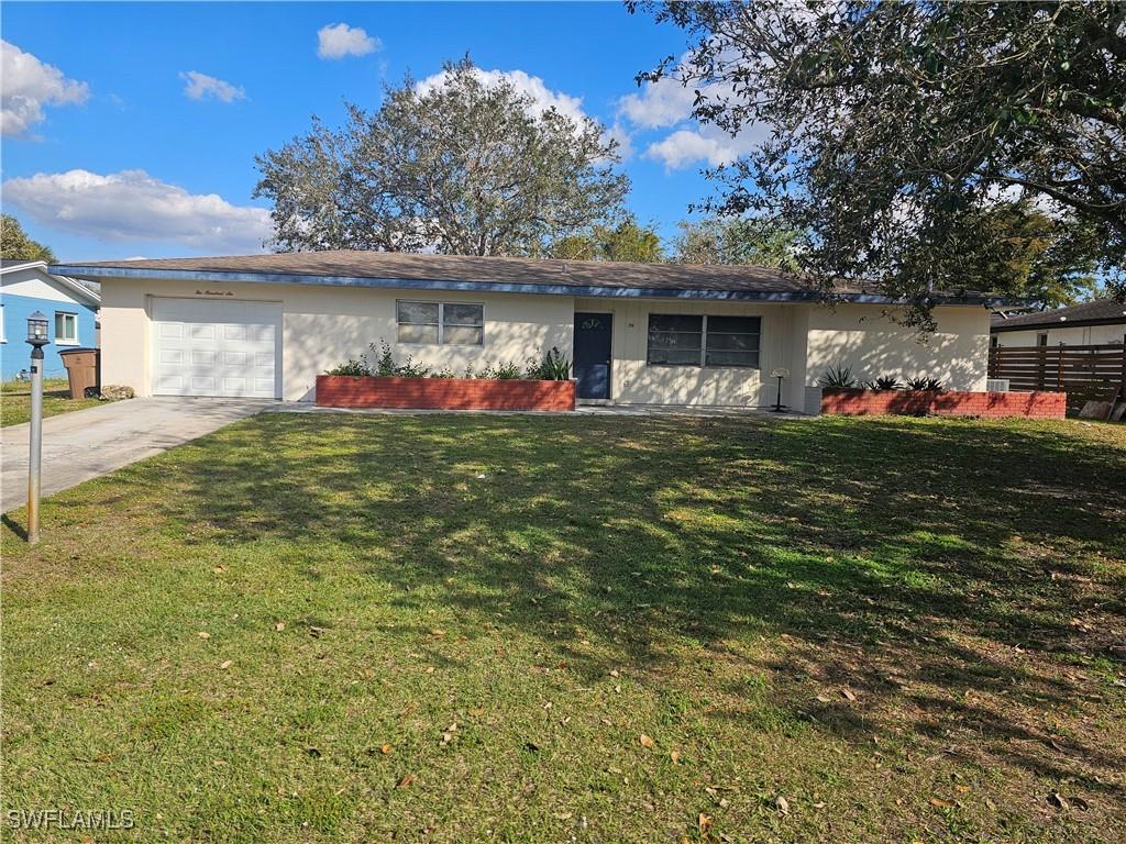 ranch-style house with a garage and a front yard