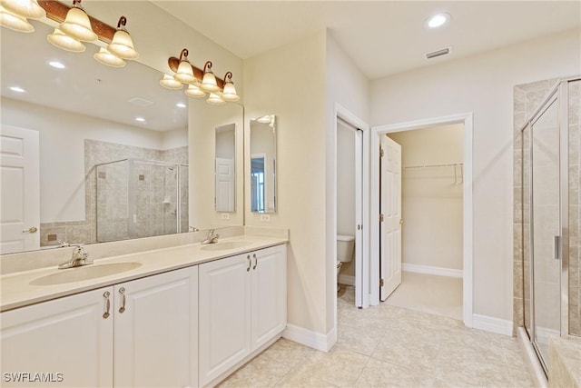 bathroom with an enclosed shower, vanity, tile patterned floors, and toilet