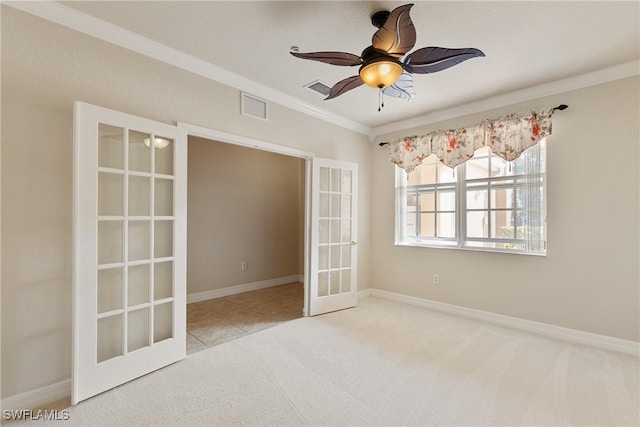 carpeted spare room featuring ornamental molding, ceiling fan, and french doors