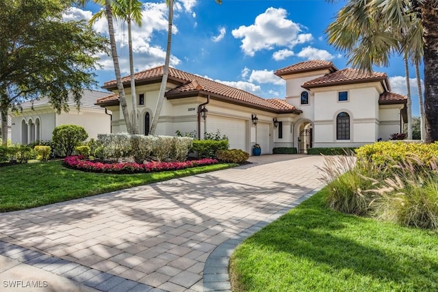 mediterranean / spanish-style house featuring a garage and a front yard