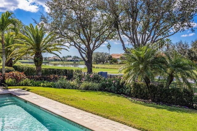 view of swimming pool featuring a water view and a yard