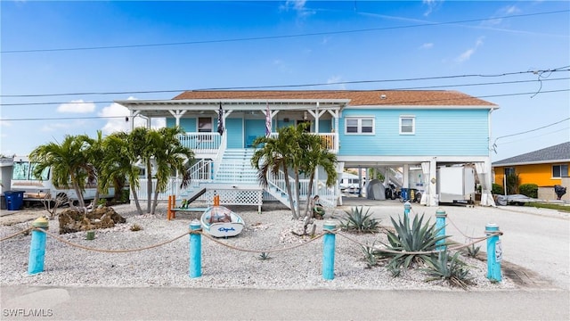 raised beach house featuring a carport and a porch