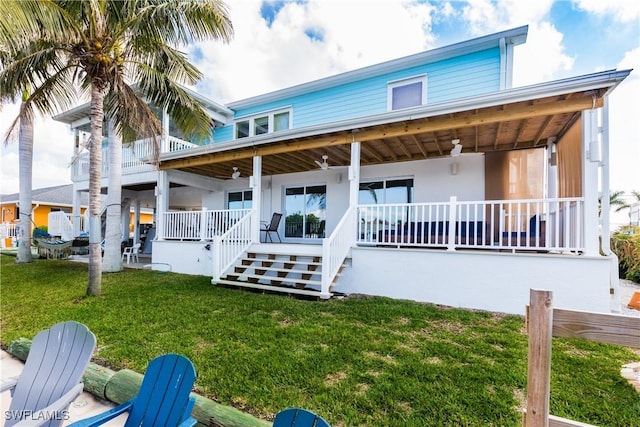 back of house with a lawn and ceiling fan