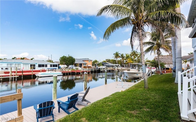 view of dock with a water view and a lawn