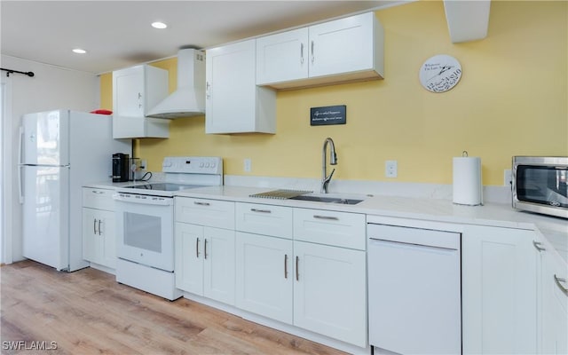 kitchen with sink, custom exhaust hood, white cabinetry, light hardwood / wood-style flooring, and white appliances