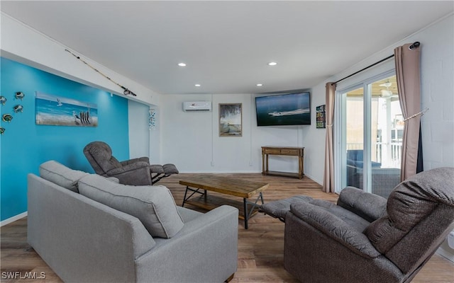 living room featuring wood-type flooring and an AC wall unit