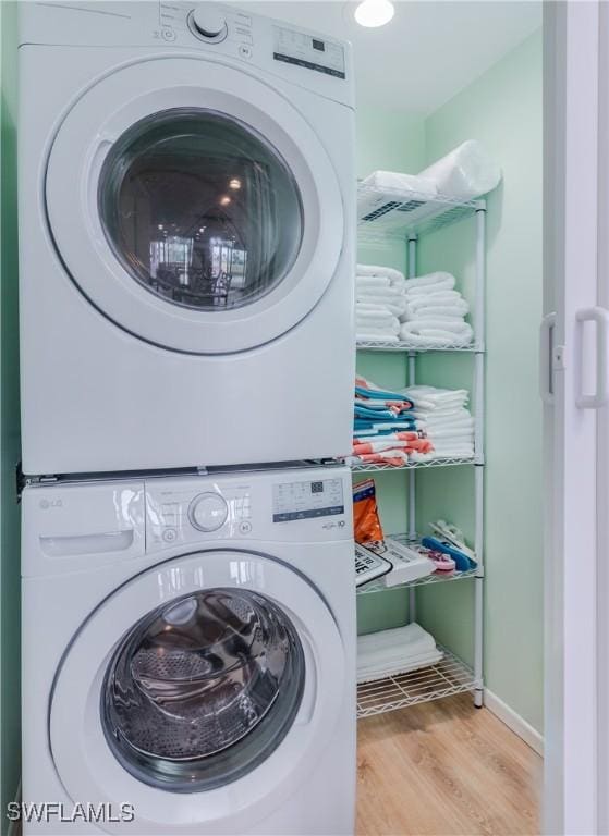 washroom featuring light hardwood / wood-style flooring and stacked washer / dryer