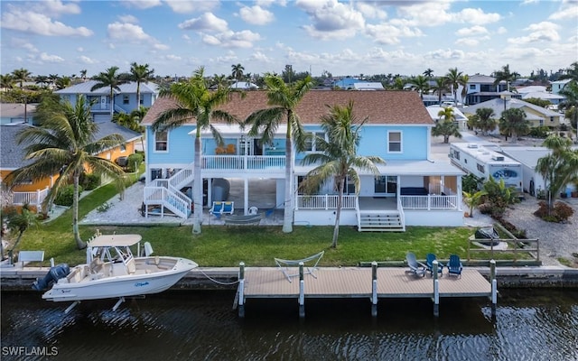 back of property featuring a water view and a yard