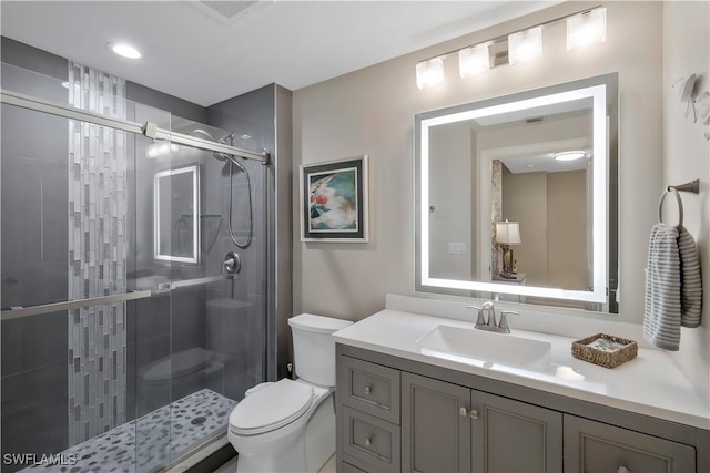 bathroom featuring vanity, toilet, and a shower with shower door