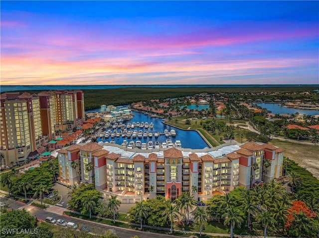 aerial view at dusk featuring a water view