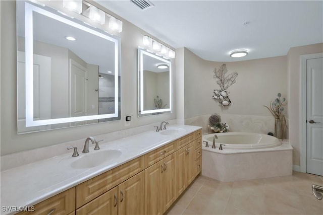 bathroom with tile patterned floors, vanity, and a washtub