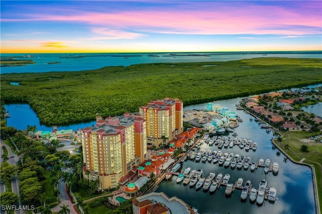 aerial view at dusk featuring a water view