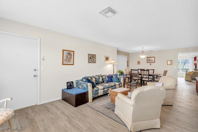 living room with light hardwood / wood-style floors and a textured ceiling