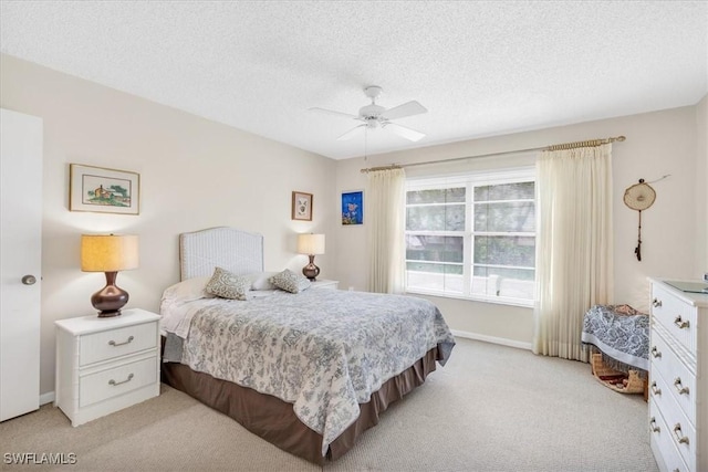 carpeted bedroom featuring ceiling fan and a textured ceiling