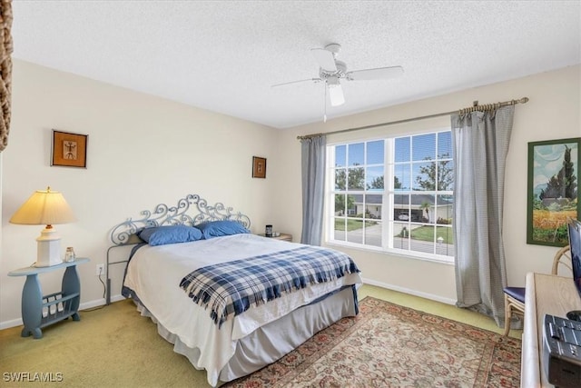 bedroom with ceiling fan, a textured ceiling, and carpet