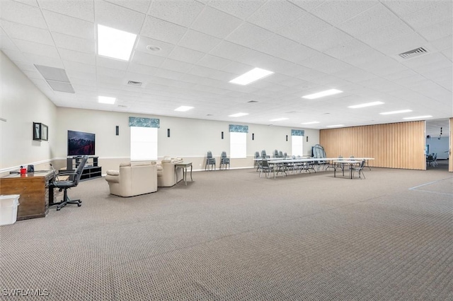 misc room with a paneled ceiling and light carpet