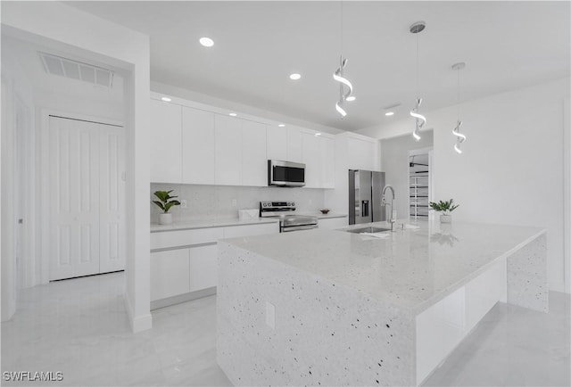 kitchen featuring pendant lighting, sink, white cabinets, and appliances with stainless steel finishes