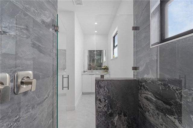 bathroom featuring vanity, a wealth of natural light, and a shower with shower door