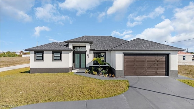 prairie-style home featuring a garage and a front lawn