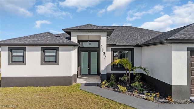 property entrance with a lawn and french doors