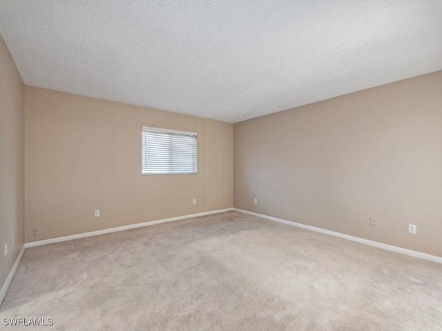 unfurnished room with light carpet and a textured ceiling