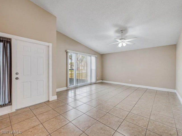 tiled spare room featuring lofted ceiling, a textured ceiling, and ceiling fan