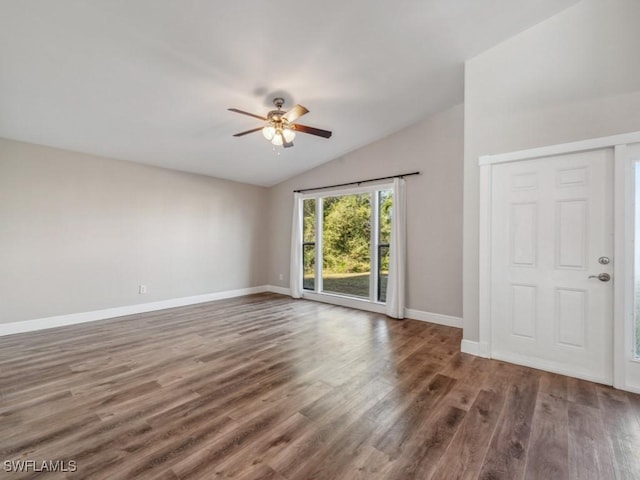 empty room featuring dark wood-type flooring, vaulted ceiling, and ceiling fan