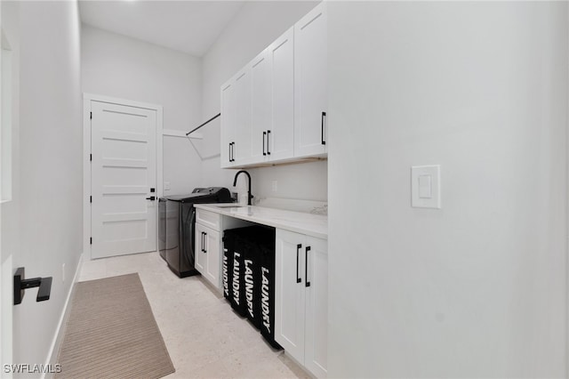 laundry area featuring cabinets, washer / clothes dryer, and sink