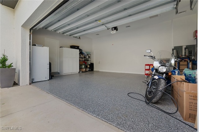 garage featuring a garage door opener and fridge