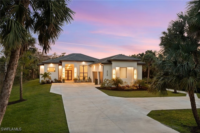 view of front of house with a yard and french doors