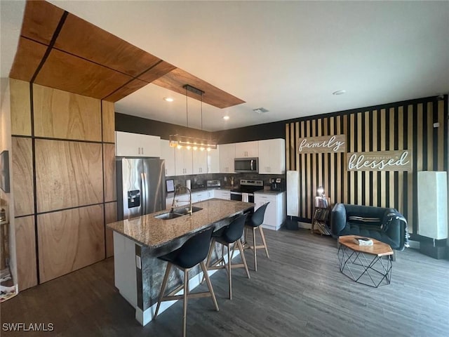 kitchen with sink, white cabinetry, a center island with sink, appliances with stainless steel finishes, and pendant lighting