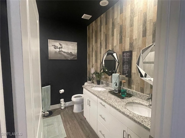 bathroom with hardwood / wood-style flooring, vanity, and toilet