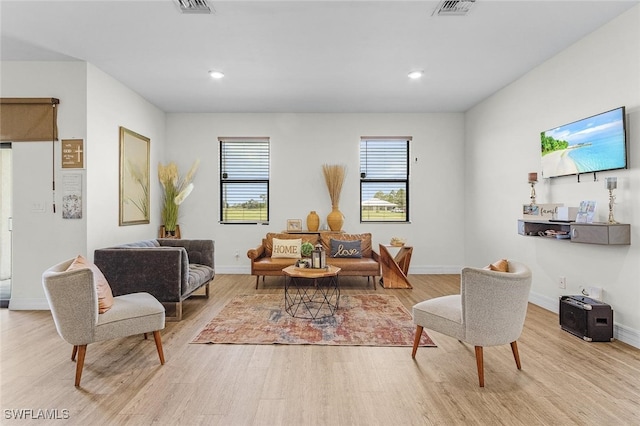 living area with visible vents, baseboards, light wood finished floors, and recessed lighting