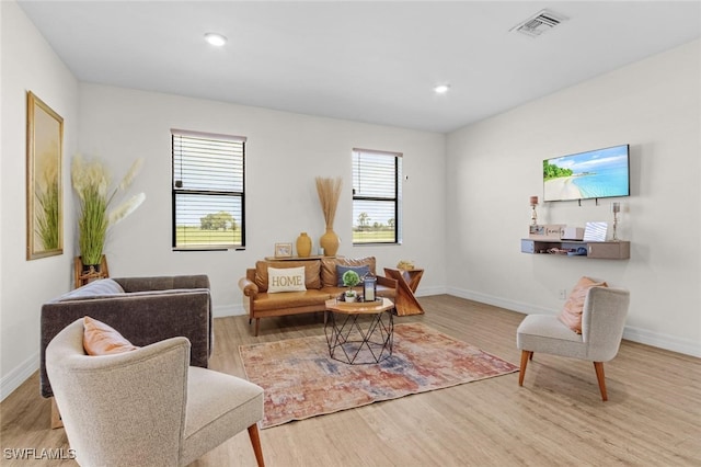living room with baseboards, visible vents, wood finished floors, and recessed lighting