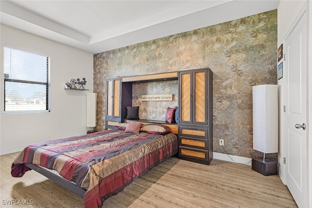 bedroom with baseboards and wood finished floors