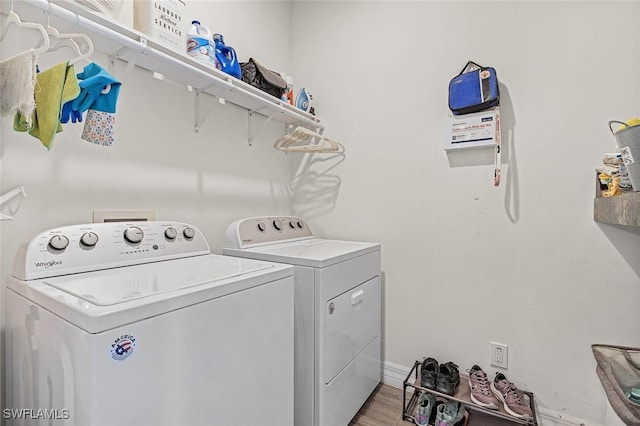 washroom with light wood-type flooring, laundry area, and washer and clothes dryer
