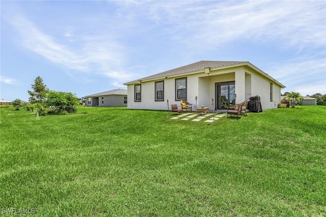 rear view of house with stucco siding and a lawn