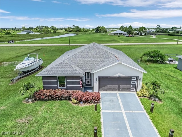 view of front of property featuring an attached garage, concrete driveway, a front lawn, roof with shingles, and stucco siding