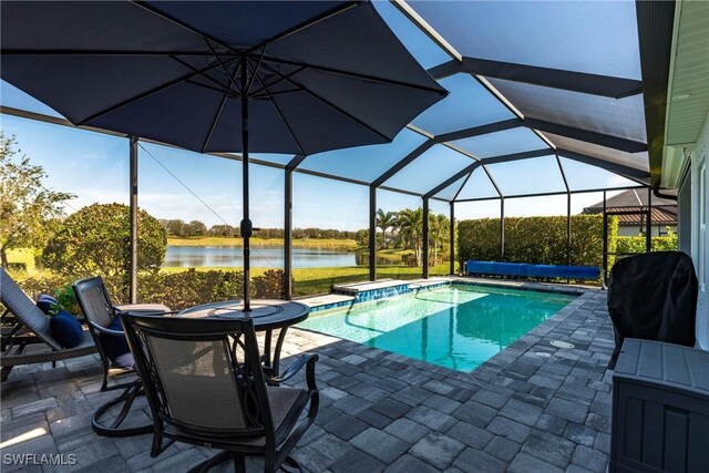 view of swimming pool featuring a water view, area for grilling, a patio, and glass enclosure