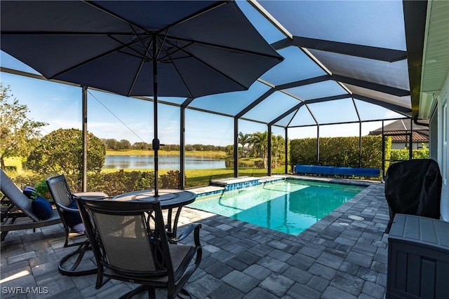 outdoor pool with glass enclosure, a water view, a patio, and grilling area