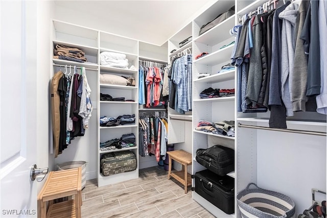 walk in closet with wood finish floors