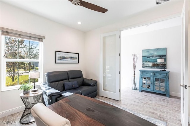 living room with ceiling fan and light wood-type flooring