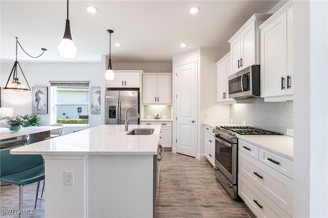 kitchen with stainless steel appliances, white cabinets, light countertops, and hanging light fixtures