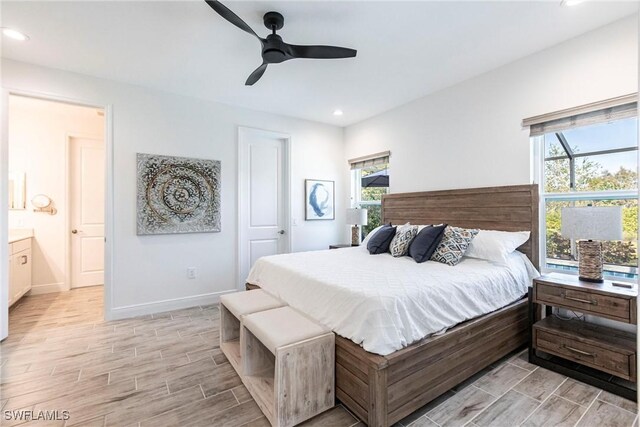 bedroom with ceiling fan, recessed lighting, wood finish floors, baseboards, and ensuite bath