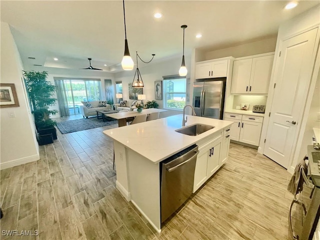 kitchen with light wood-style flooring, white cabinets, stainless steel appliances, and a sink