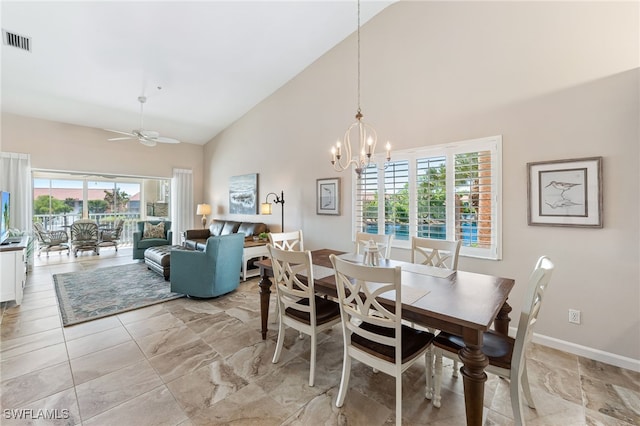 dining space featuring ceiling fan with notable chandelier and high vaulted ceiling