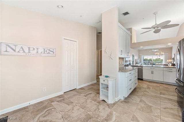 kitchen with sink, ceiling fan, stainless steel appliances, light stone counters, and white cabinets