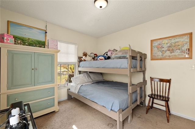 bedroom featuring light carpet and a textured ceiling