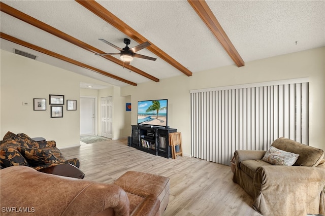 living room with vaulted ceiling with beams, light hardwood / wood-style flooring, a textured ceiling, and ceiling fan